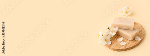 Board with natural soap bars and jasmine flowers on light background with space for textt photo