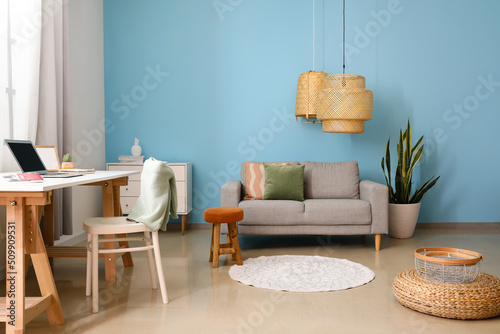 Interior of modern living room with comfortable sofa, houseplant and lamp