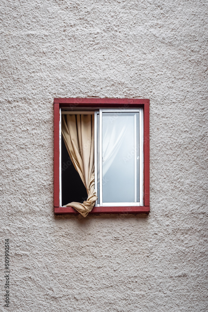 Small Open Window with a Red Frame and a Yellow Curtain on the Inside