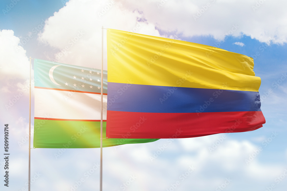 Sunny blue sky and flags of colombia and uzbekistan Sunny blue sky and flags of colombia and uzbekistan
