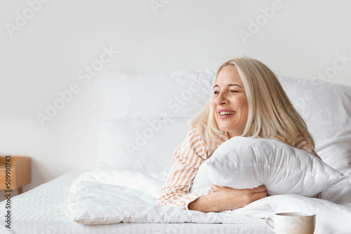 Morning of beautiful mature woman in bedroom