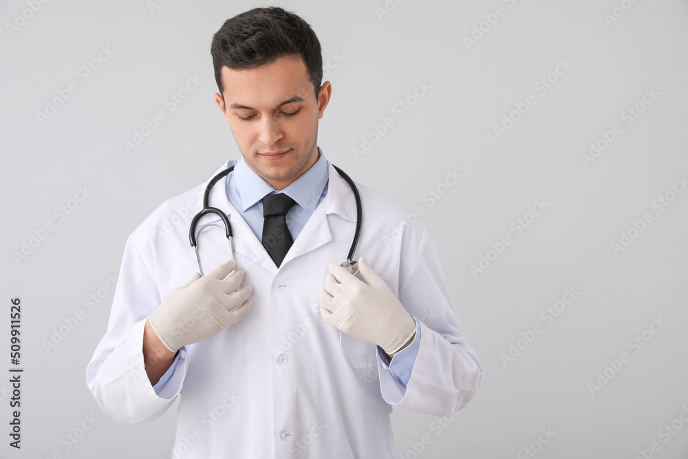 Male doctor with stethoscope on grey background Male doctor with stethoscope on grey background