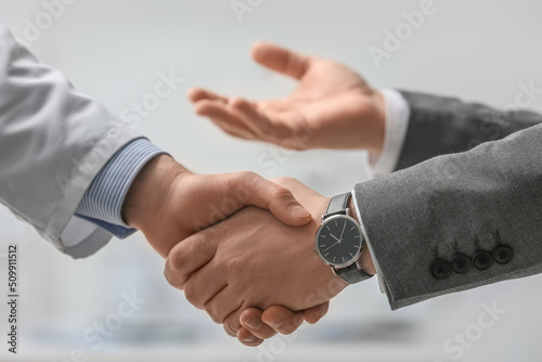Doctor and patient shaking hands in clinic photo