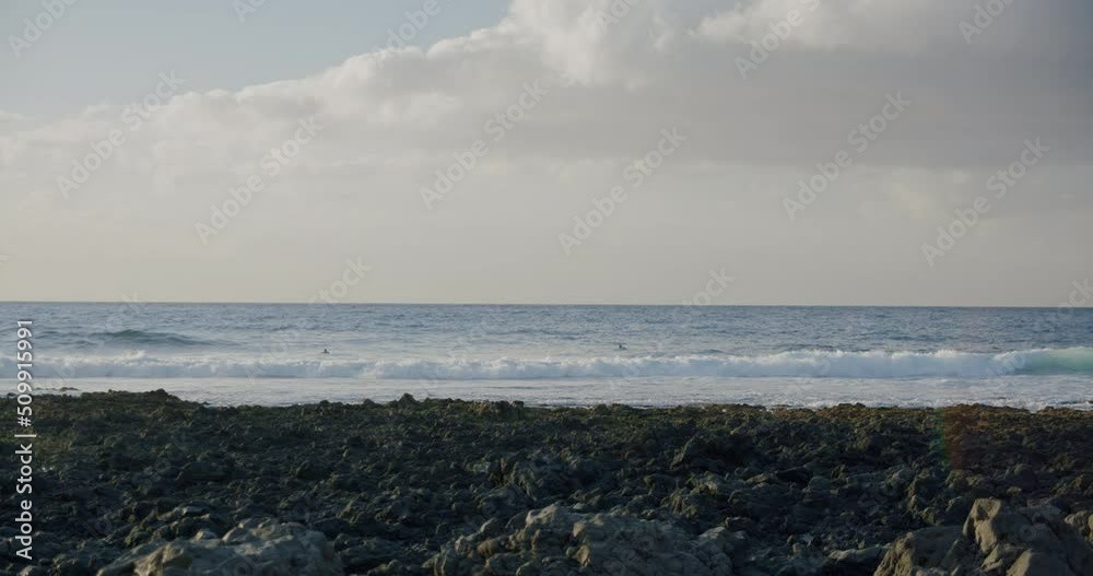 Black rocky volcanic beach with black lava stones. Puerto de Santiago, Tenerife. Punta Blanca or Punta Juanita - best place to surf or chill relax. Black rocky volcanic beach with black lava stones. Puerto de Santiago, Tenerife. Punta Blanca or Punta Juanita - best place to surf or chill relax.