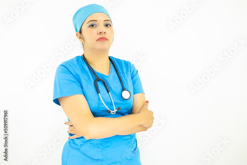 Beautiful female doctor wearing uniform and blue surgical cap, professional woman with stethoscope on her neck on white background