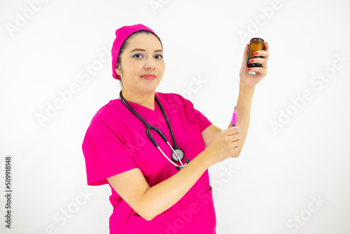 beautiful woman medical assistant wearing uniform and pink surgical cap, stethoscope, preparing injection on white background
