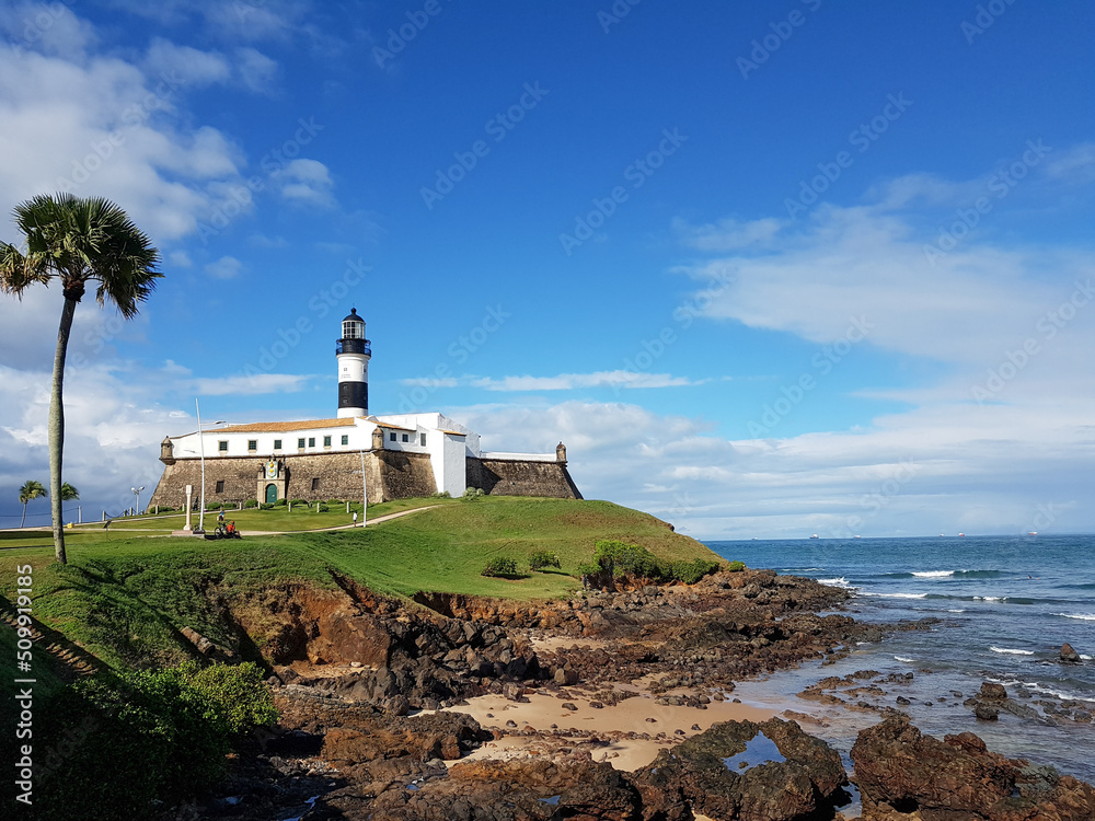 Lighthouse built over old stone fort on Salvador beach in Bahia