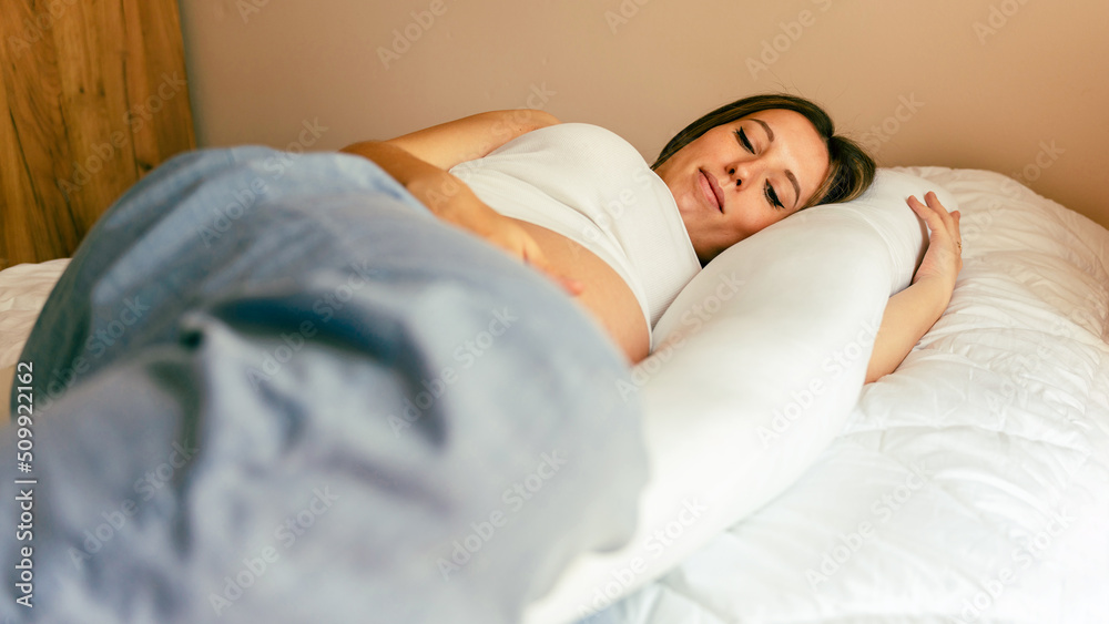 Pregnant pillow woman sleeping. Young pregnancy mother sleep with
