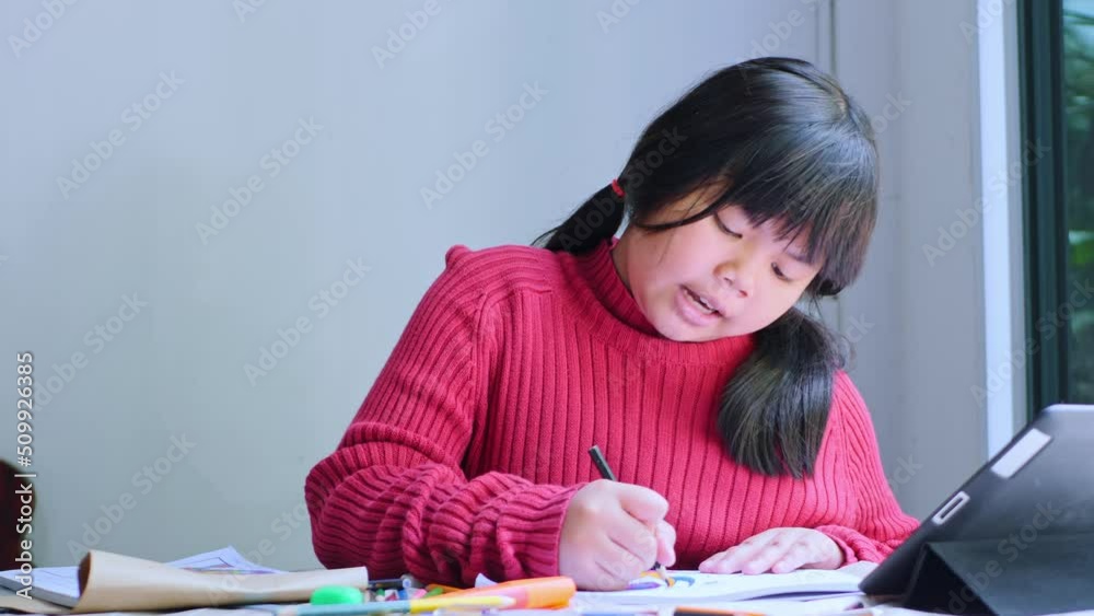 Asian girl sitting at home coloring pictures. Asian girl sitting at home coloring pictures.