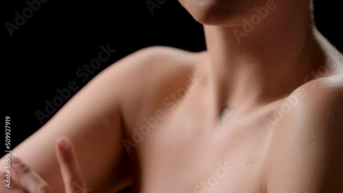 Wallpaper Mural Big close-up shot of good-looking young slim white-skinned woman strokes her shoulders, arms and collarbone turning on black background | Soft skin concept Torontodigital.ca