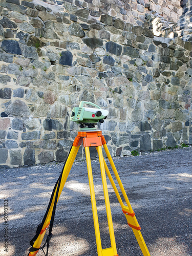 Digital level in front of church ruins