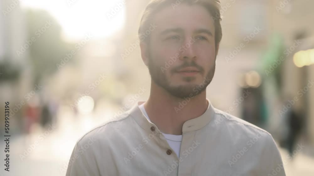Sunny portrait of attractive young blond man standing in the city street and looking ahead. Handsome guy outside. Sunny portrait of attractive young blond man standing in the city street and looking ahead. Handsome guy outside.