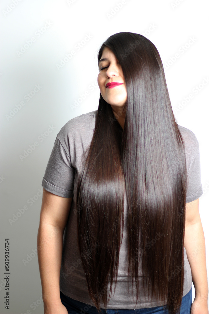 Latin young adult woman shows how silky and shiny her black hair