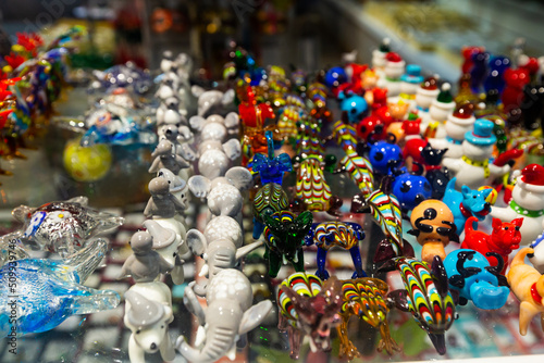 Variety of Murano glass products on shelves of souvenir shop in Venice..