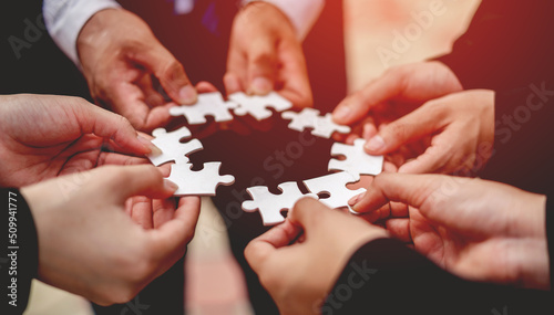 Close-up of a businessman with puzzle pieces in his hands arranged together. teamwork unity in teamwork The concept of combining physical strength and power at work.