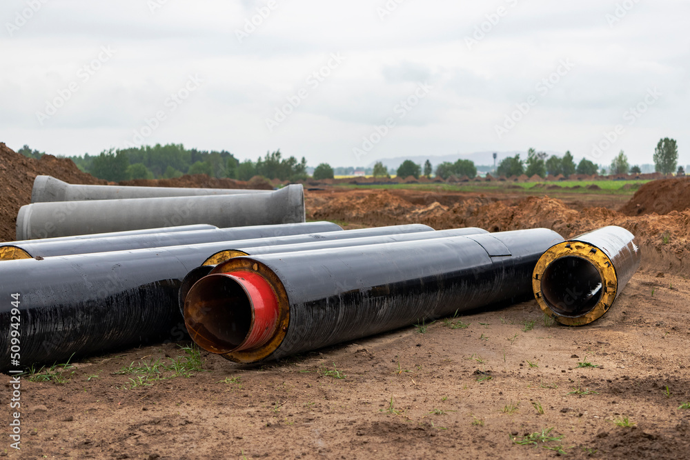 Insulated pipe. Large metal pipes with a plastic sheath laid in a trench. Modern pipeline for supplying hot water and heating to a residential area. Insulated pipe. Large metal pipes with a plastic sheath laid in a trench. Modern pipeline for supplying hot water and heating to a residential area.