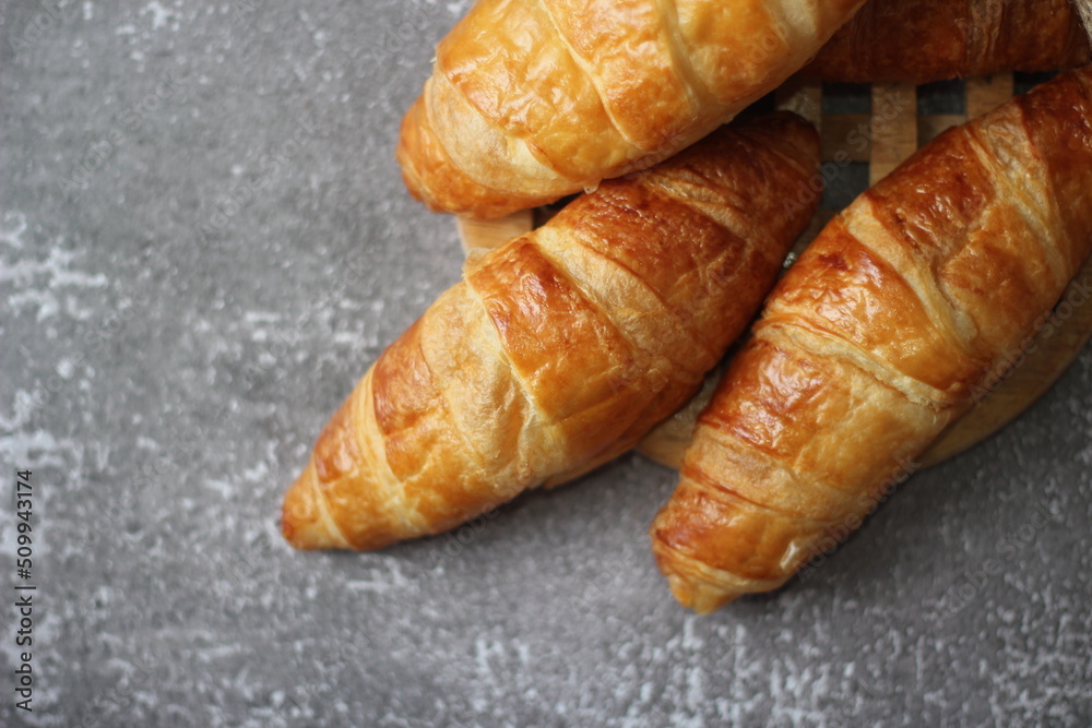 Croissant bread stacked on the table with wooden plates and sackcloth. Croissant bread stacked on the table with wooden plates and sackcloth.