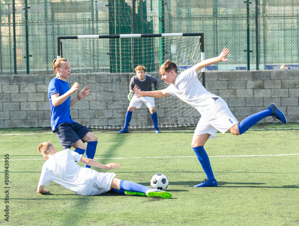 Fototapeta premium Teens playing soccer football match. Competition between two youth soccer teams. Football soccer tournament