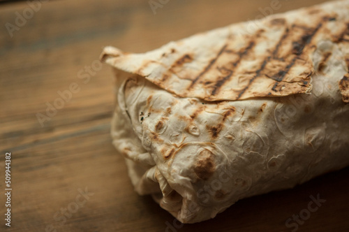 Shawarma wrap sandwich on white wood table arabic food sauce