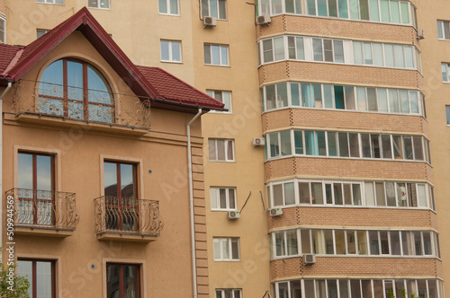 apartment building with colorful facades. Modern minimalistic architecture with lots of square glass Windows and flowers on the building.