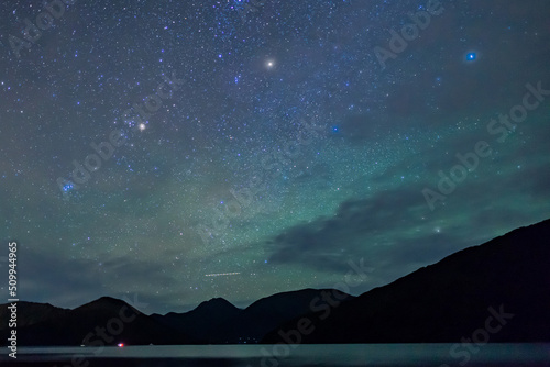 Clear starry sky above the shape of mountains in a fjord in the Marlborough Sounds, New Zealand