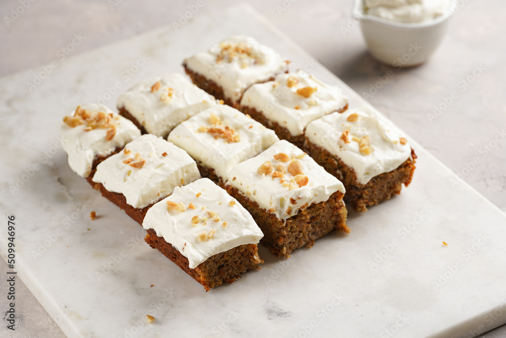 Homemade pastry carrot-walnut cake with grounded almonds and hazelnuts and white cream cheese top layer on marble board Homemade pastry carrot-walnut cake with grounded almonds and hazelnuts and white cream cheese top layer on marble board