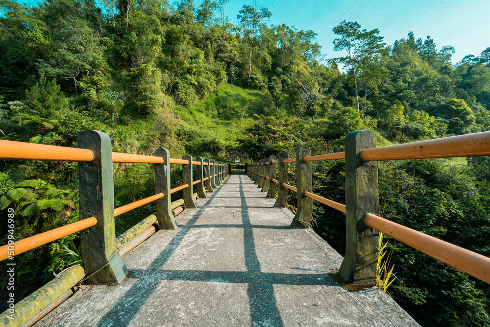 Iconic bridge in one of the tourist destinations in Kali Kuning, Sleman, Indonesia with green hills in the morning Iconic bridge in one of the tourist destinations in Kali Kuning, Sleman, Indonesia with green hills in the morning