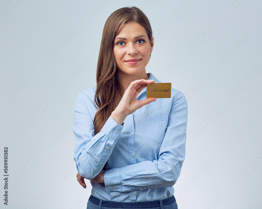 Fototapeta premium Smiling woman bank employee holding credit card. Business woman with long hair wearing blue shirt.