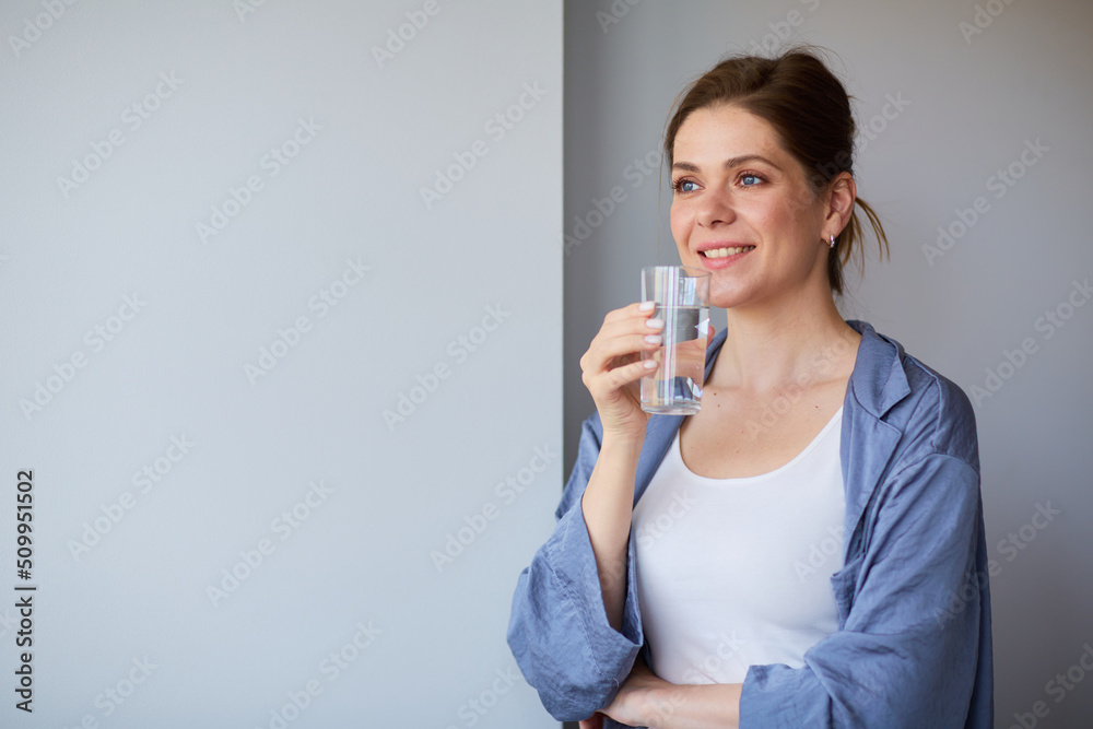 Happy smiling woman drinking water looking away. Happy smiling woman drinking water looking away.