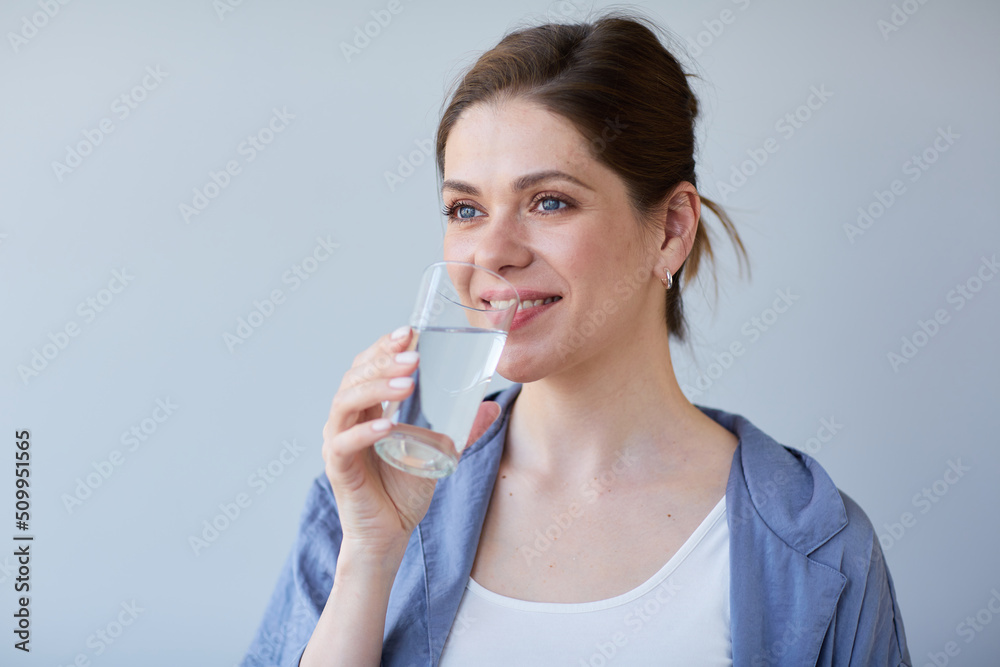 Close up head shot of smiling woman drinking water and looking away. Close up head shot of smiling woman drinking water and looking away.
