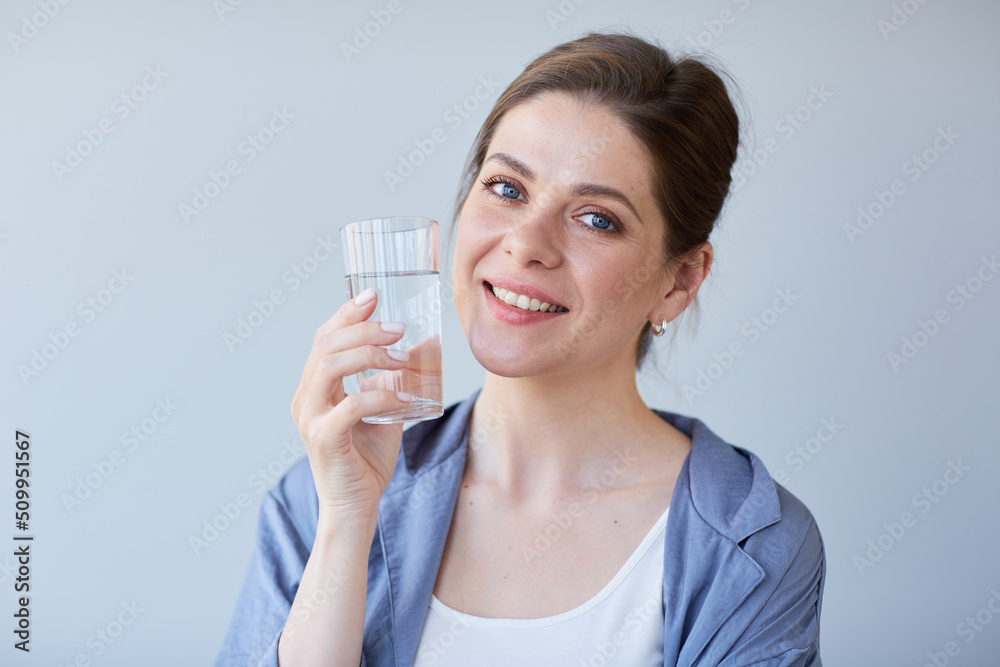 Happy smiling woman wearing pajamas holding water or some drink in glass. Happy smiling woman wearing pajamas holding water or some drink in glass.
