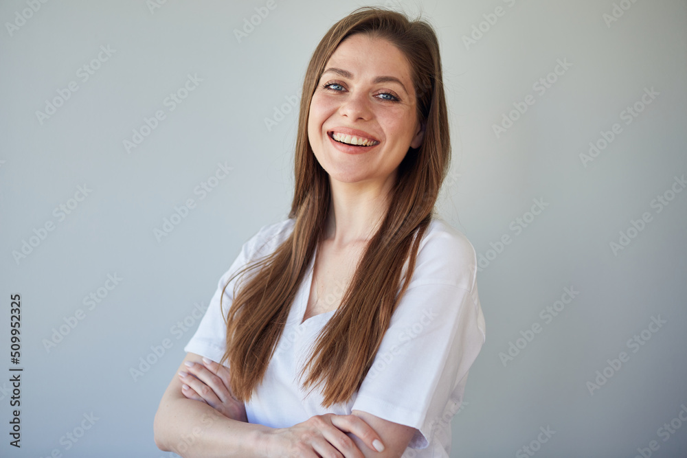 Smiling woman in white shirt portrait with crossed arms. Happy girl in white casual clothes. Smiling woman in white shirt portrait with crossed arms. Happy girl in white casual clothes.