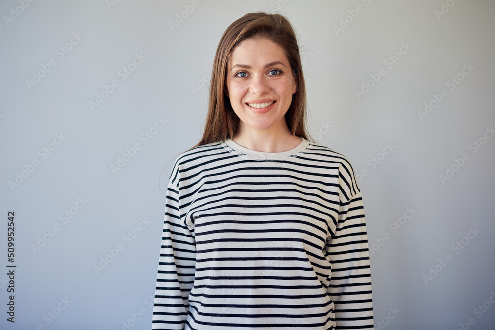 Beautiful smiling woman with natural skin and long hair. Isolated portrait of girl wearing casual clothes on gray background. Beautiful smiling woman with natural skin and long hair. Isolated portrait of girl wearing casual clothes on gray background.