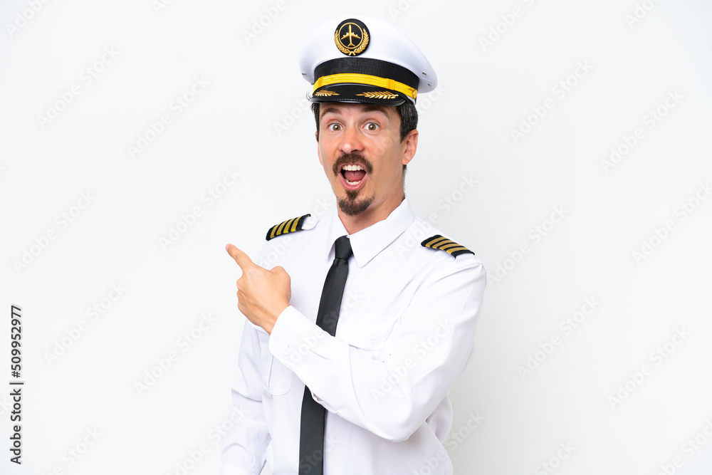 Airplane caucasian pilot isolated on white background surprised and pointing side