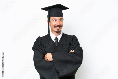 Young university graduate man isolated on white background looking up while smiling