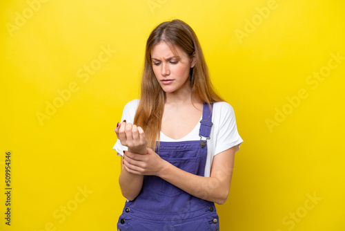 Young caucasian woman isolated on yellow background suffering from pain in hands