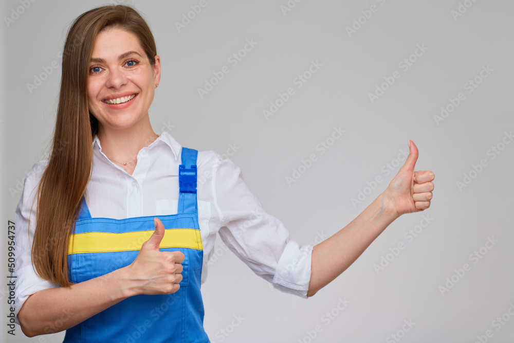 Smiling woman in blue overall uniform pointing her finger at empty copy space. Smiling woman in blue overall uniform pointing her finger at empty copy space.