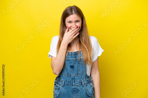 Young caucasian woman isolated on yellow background happy and smiling covering mouth with hand