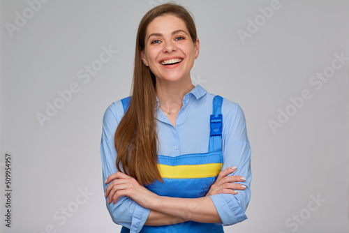 Smiling woman worker plumber or elictrician in blue uniform overalls standing with arms crossed. isolated portrait of happy girl with long hair and big toothy smile.