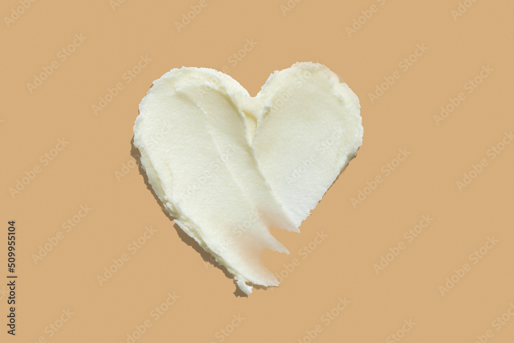 Heart shape shea butter cream texture smudge stroke on beige brown color background - obrazy, fototapety, plakaty 