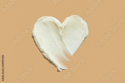 Heart shape shea butter cream texture smudge stroke on beige brown color background