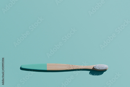 Bamboo Toothbrush on blue background, organic eco wooden toothbrush with copy space