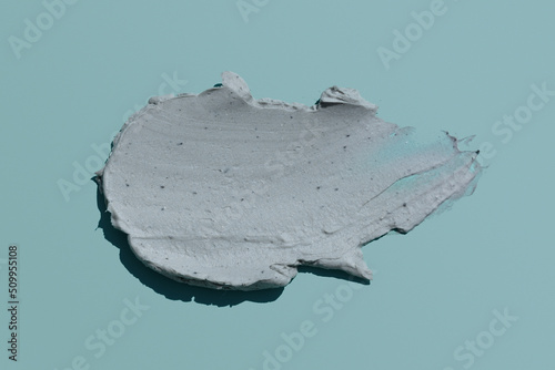 Thick cream clay face mask texture smear swatch on grey mint colour background, skin care scrub product smudge stroke flat lay