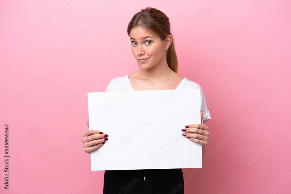 Young caucasian woman isolated on pink background holding an empty placard Young caucasian woman isolated on pink background holding an empty placard