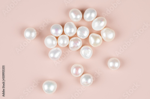 Natural freshwater round pearl beads on pink background. Top view