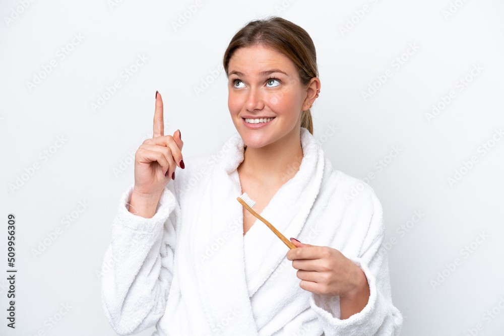 Young caucasian woman brushing teeth isolated on white background intending to realizes the solution while lifting a finger up