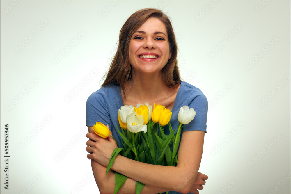 happy smiling woman holding flowers in front of happy smiling woman holding flowers in front of