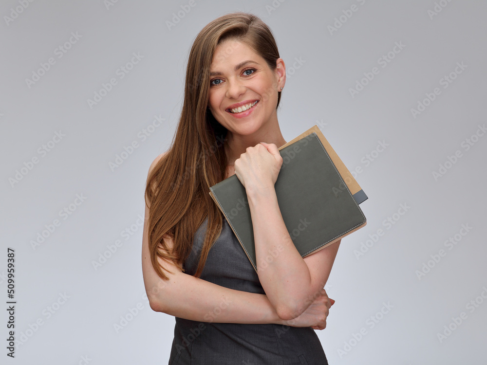 Smiling teacher or woman student in gray business dress standing with books, isolated portrait. Smiling teacher or woman student in gray business dress standing with books, isolated portrait.