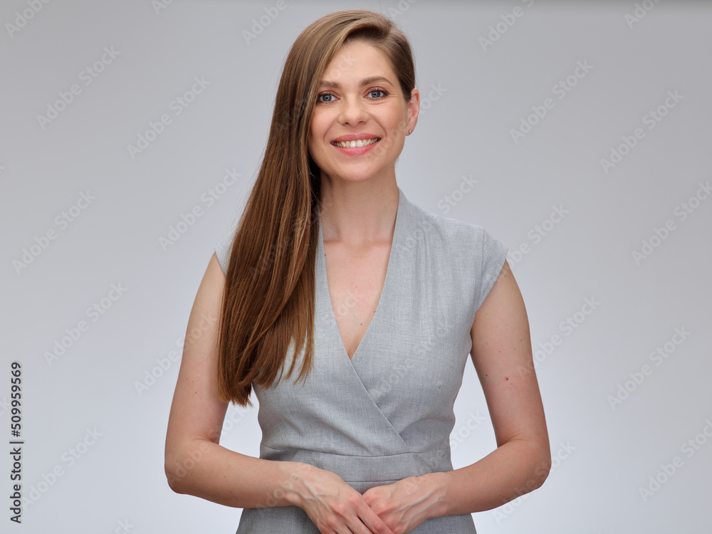 Smiling woman in gray business dress standing with folded hands, isolated on gray background. Smiling woman in gray business dress standing with folded hands, isolated on gray background.