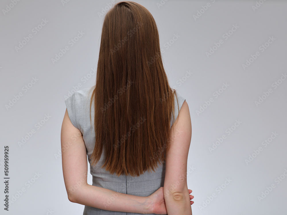 Woman back standing with long hair wearing business dress, isolated portrait. Woman back standing with long hair wearing business dress, isolated portrait.